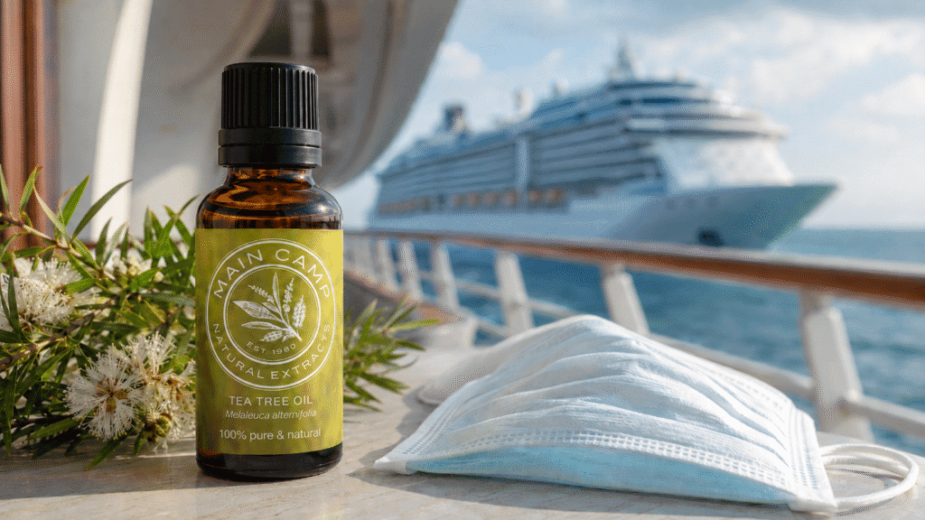 Australian Tea Tree Oil bottle with tea tree flowers, face mask and cruise ship background, representing natural hygiene, sanitising applications and pandemic preparedness.